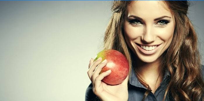 Meitene ar ābolu rokā