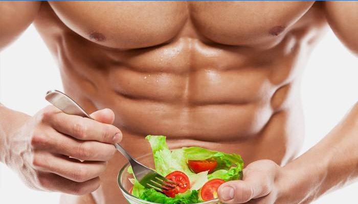 Sportists vīrietis ēd svaigu dārzeņu salātus